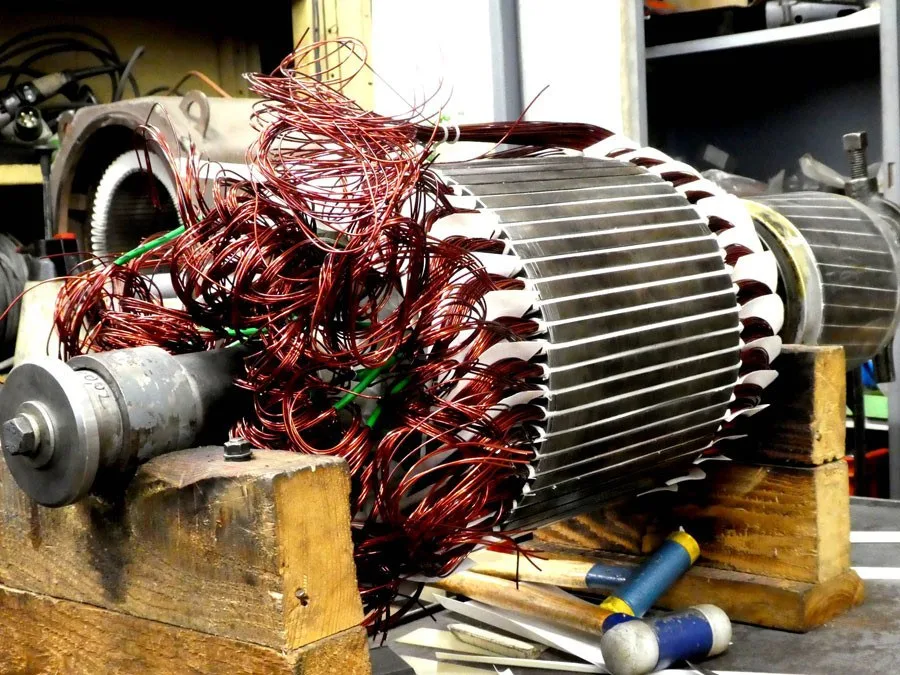 Anker in der Neuwicklung, lose Kupferdrähte, auf Holzböcken in der Werkstatt