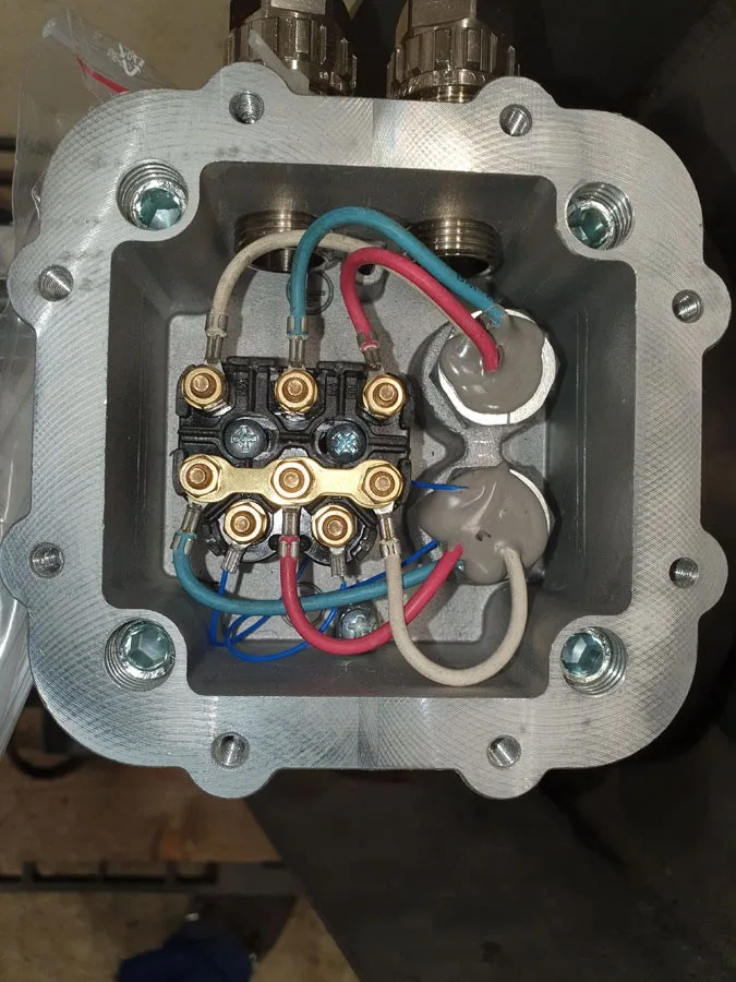 Geöffneter Klemmkasten eines Elektromotors mit Anschlussklemmen und Leitungen