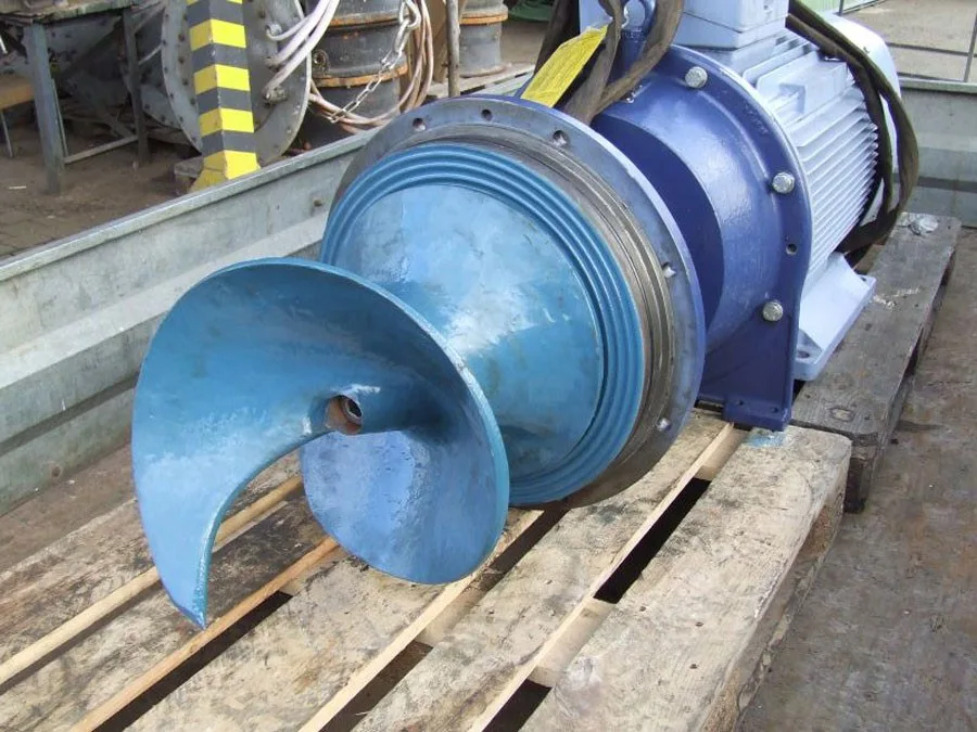 Blaue Pumpe mit Förderschnecke auf einer Holzpalette im Hof